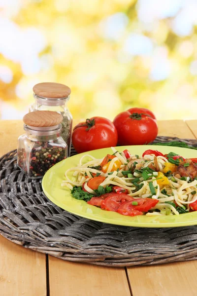 Nudeln mit Gemüse in Tellern auf hellem Hintergrund — Stockfoto