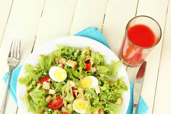 Caesar-Salat auf weißem Teller, auf farbigem Holzhintergrund — Stockfoto
