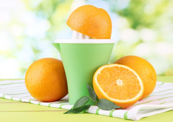 柑橘類を押してと熟したオレンジ緑の木製テーブル — ストック写真