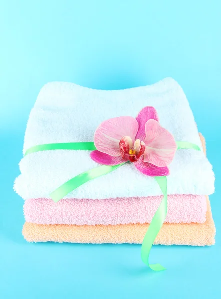 Towels tied with ribbon on blue background — Stock Photo, Image