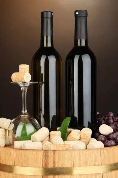 Wijn en kurken op vat op bruine achtergrond — Stockfoto