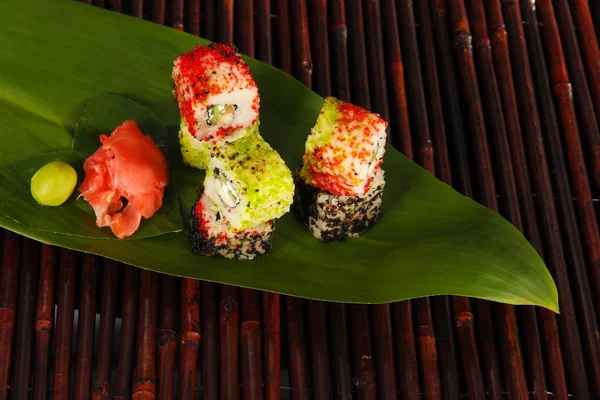 Sabroso sushi Maki - Roll on green leaf on bamboo mat —  Fotos de Stock