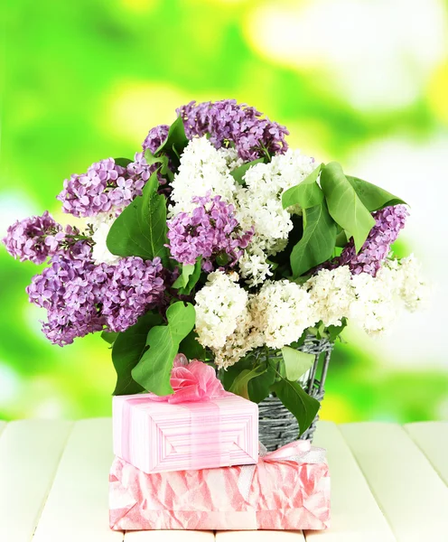 Beautiful lilac flowers, on wooden table on bright background — Stock Photo, Image