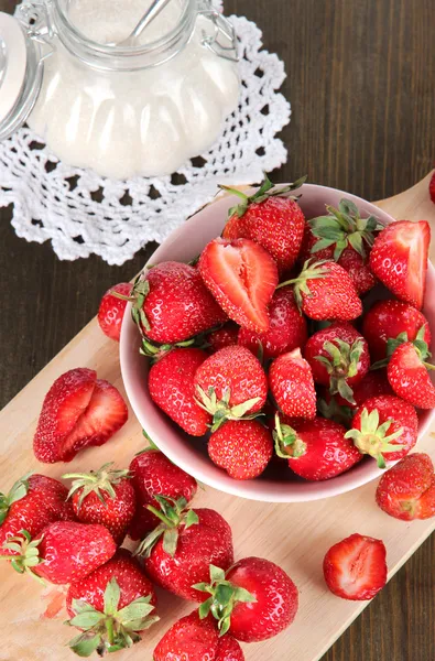 Erdbeeren in Schüssel auf Holztisch schneiden — Stockfoto