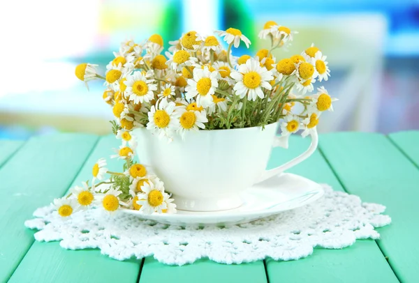 Bouquet di fiori di camomilla in tazza, su sfondo luminoso — Foto Stock