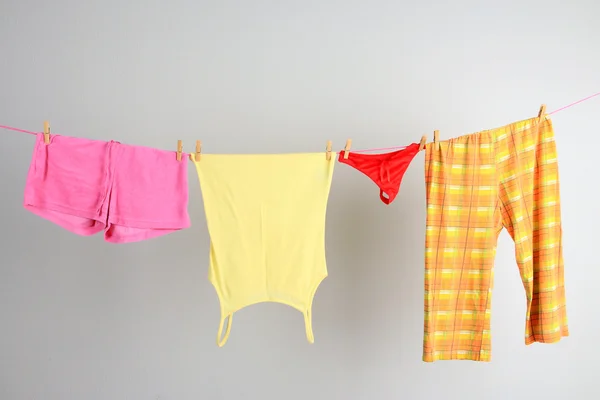 Linea di lavanderia con vestiti su sfondo parete — Foto Stock