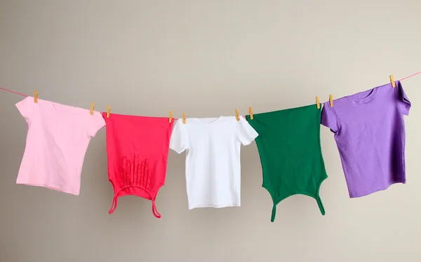 Laundry line with clothes on wall background — Stock Photo, Image
