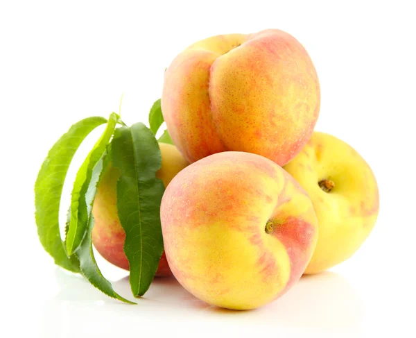 Reife süße Pfirsiche mit Blättern, isoliert auf weiß — Stockfoto