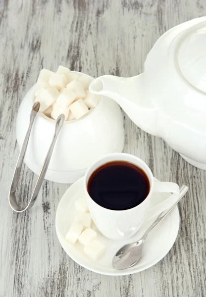 Tasse Kaffee, Teekanne und Zuckerdose auf farbigem Holzhintergrund — Stockfoto