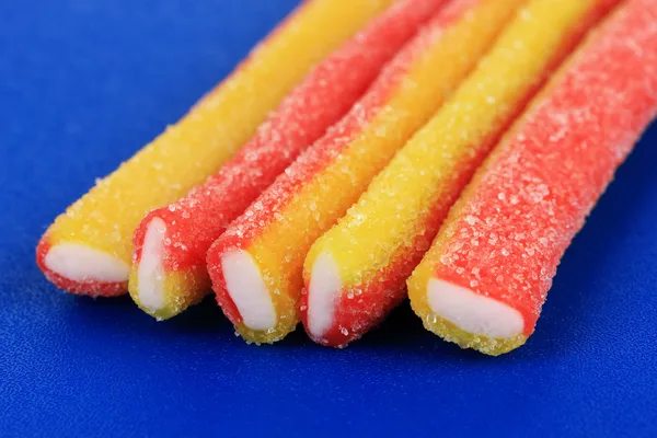 Süße Gelee-Bonbons auf blauem Hintergrund — Stockfoto