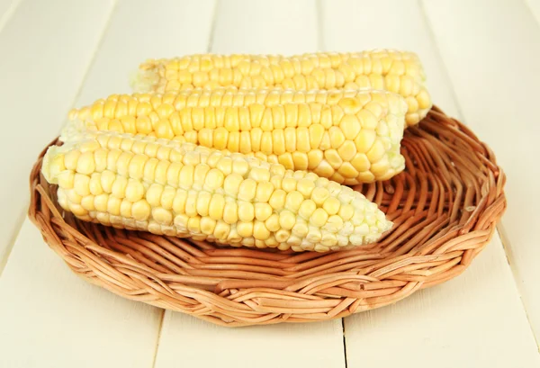 Verse maïs op rieten mat, op houten achtergrond — Stockfoto