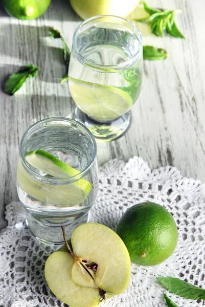 Glazen cocktail met kalk op servet op licht houten tafel — Stockfoto