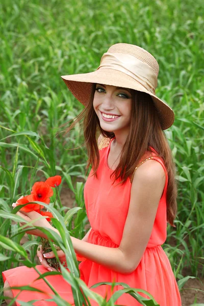 Portrait of beautiful young woman with poppies in the field — Stock Photo, Image