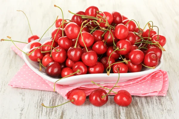 Cherry berries on plate on wooden table close up — Stock Photo, Image