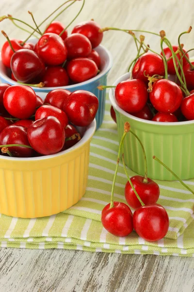 Baies de cerises dans des bols sur une table en bois fermer — Photo