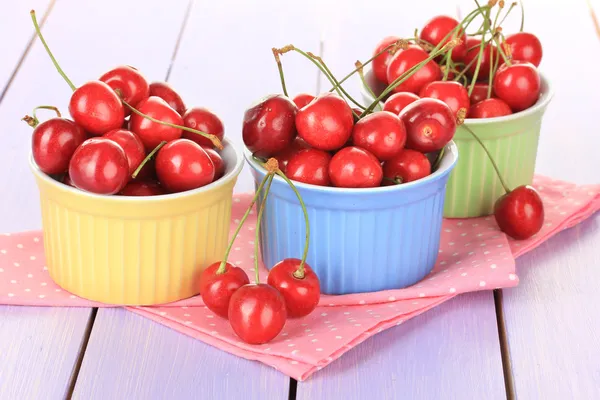 Bayas de cereza en cuencos sobre mesa de madera de cerca — Foto de Stock