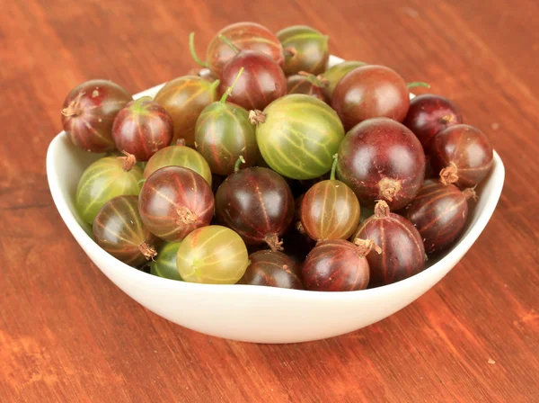 Bayas de grosella frescas en tazón en primer plano de la mesa —  Fotos de Stock