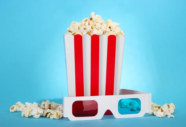 Palomitas de maíz y gafas 3D sobre fondo azul — Foto de Stock