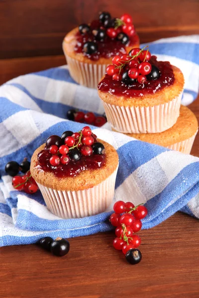 Smakelijke muffins met bessen op houten tafel — Stockfoto