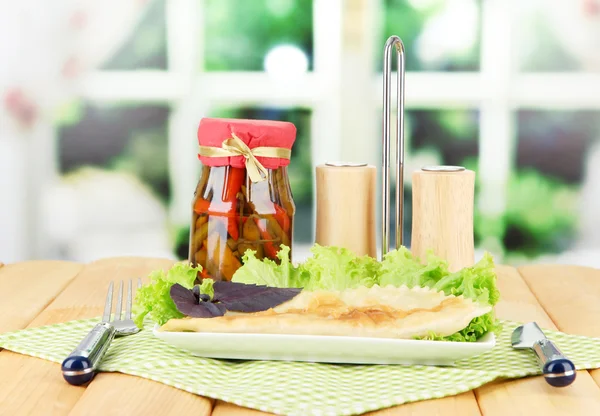 Chebureks saborosos com ervas frescas na placa, na mesa de madeira, no fundo brilhante — Fotografia de Stock
