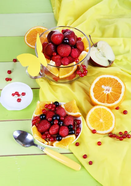 Insalata di frutta utile in tazza di vetro e ciotola sul tavolo di legno primo piano — Foto Stock