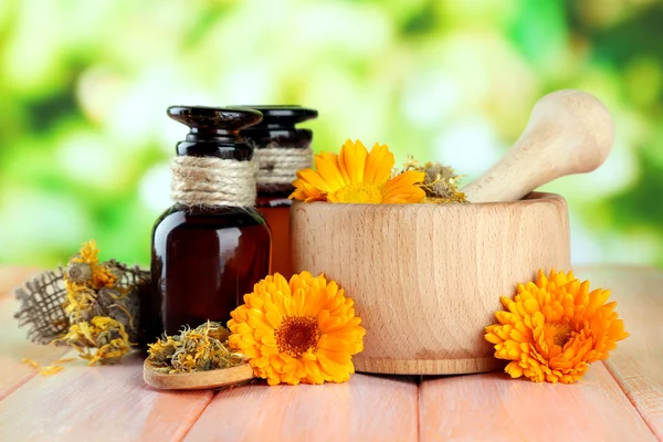 Medicin flaskor och ringblomma blommor på träbord — Stockfoto