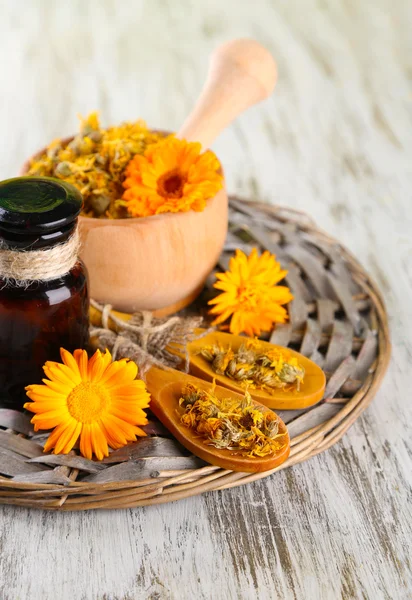 Medicin flaskan och ringblomma blommor på trä bakgrund — ストック写真