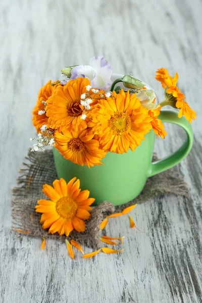 Calendula bloemen in cup op houten achtergrond — Stockfoto