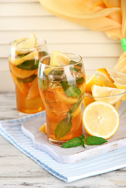 Té helado con limón y menta sobre mesa de madera —  Fotos de Stock