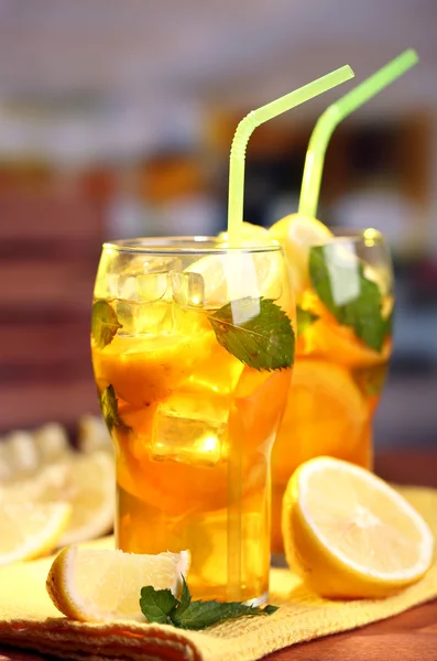 Té helado con limón y menta en la mesa de madera, al aire libre —  Fotos de Stock