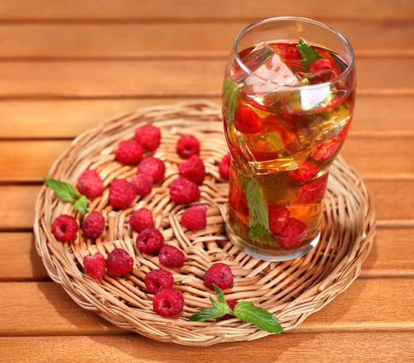 Iced tea with raspberries and mint on wooden table — Stock Photo, Image