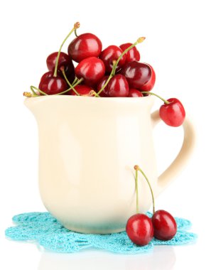 Olgun kırmızı kiraz meyveleri üzerinde beyaz izole sürahi