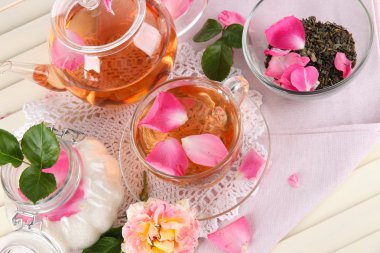 Kettle ve çay gülü peçete ahşap zemin üzerinde gelen