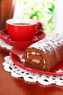 odasındaki masada çay ile tatlı rulo