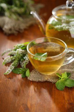 fincan ve ahşap masa çiçekleri taze nane ile bitkisel çay demlik