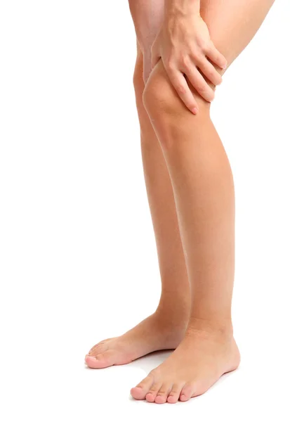 Жінка тримає болючу ногу, ізольована на білому — стокове фото