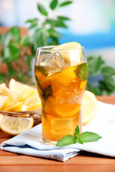 Té helado con limón y menta en la mesa de madera, al aire libre —  Fotos de Stock