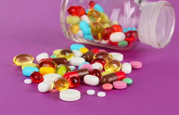 Sortiment av piller, tabletter och kapslar på lila bakgrund — Stockfoto