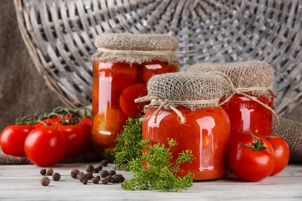 Sabrosos tomates enlatados y frescos sobre mesa de madera —  Fotos de Stock