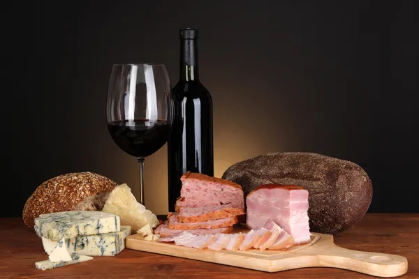 Exquisito bodegón de vino, queso y productos cárnicos — Foto de Stock