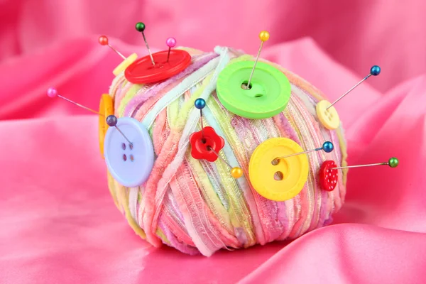 Colorful buttons and multicolor wool ball, on color fabric background — Stock Photo, Image