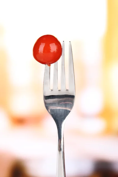 Черри помидор прилипает к вилке, на ярком фоне — стоковое фото