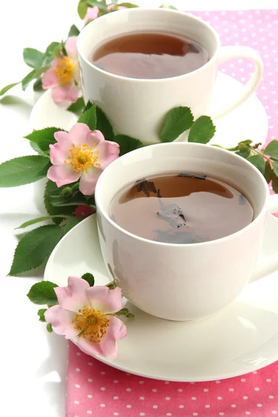 Cups of herbal tea with hip rose flowers, isolated on white — Stock Photo, Image