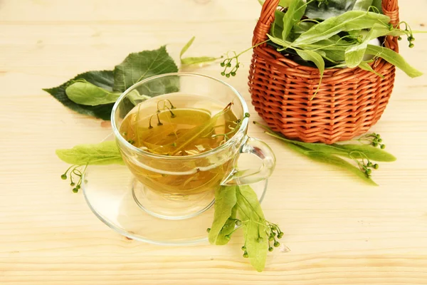 Glass cup of tea with linden on wooden table close-up — Stock Photo, Image