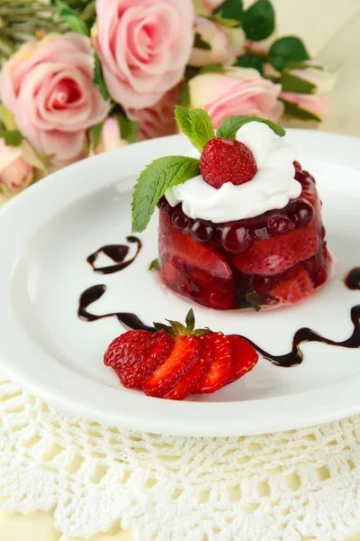 Вкусный желейный десерт со свежими ягодами, на цветном деревянном фоне — стоковое фото