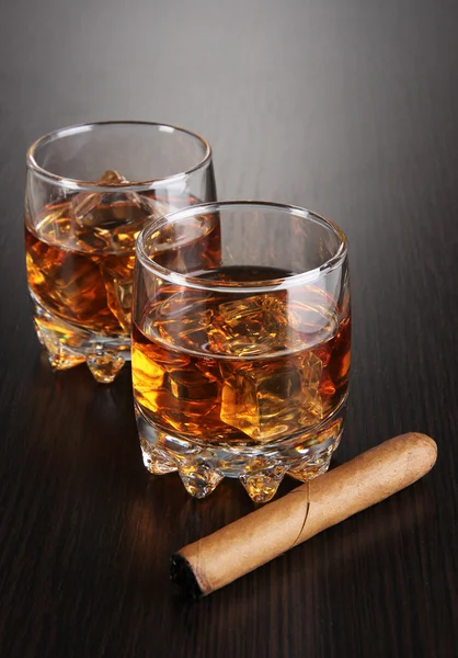 Brandy glasses with ice on wooden background — Stock Photo, Image