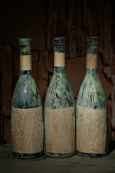 Old bottles of wine in old cellar, on dark background — Stock Photo, Image