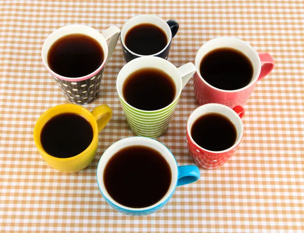 Veel kopjes koffie op geruite servet — Stockfoto