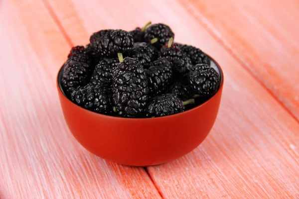 Ripe mulberries in bowl on wooden background — Stock Photo, Image