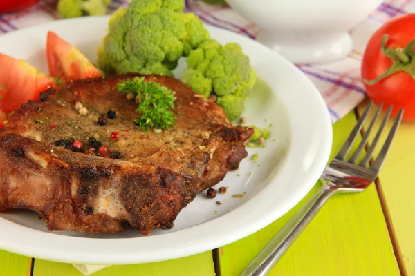 Piece of fried meat on plate on wooden table close-up — Stock Photo, Image